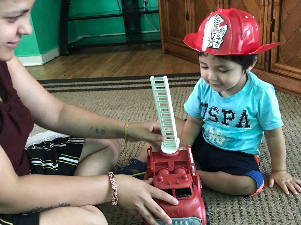 young boy plays with firetruck