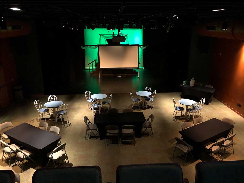 theater space with tables and chairs